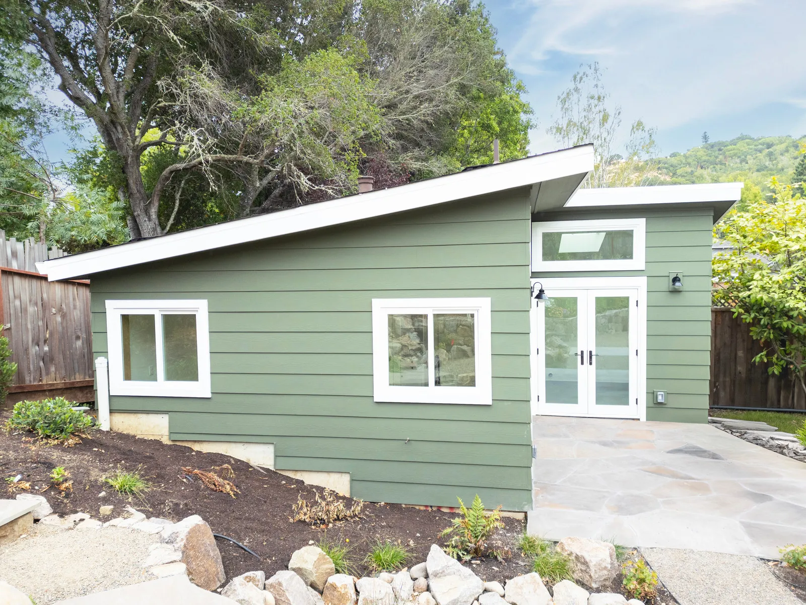 60 Tarry — sage-green detached ADU with shed roof and stone patio